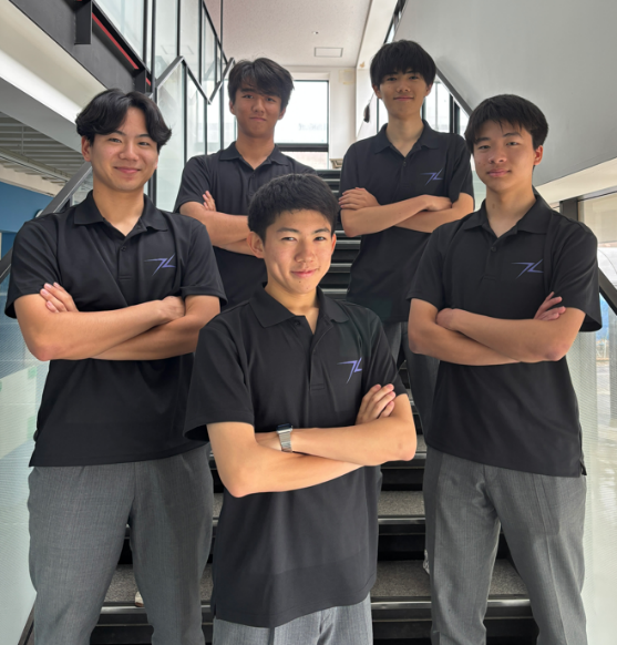 茗溪学園高校の校舎内にて、STEM レーシングチーム「LAP17」のチームポロシャツを着用するメンバー。（前列左から）西山紘章さん、川島一瑚さん、宗澤武寛さん。（後列左から）伊藤拓真さん、平林哲明さん