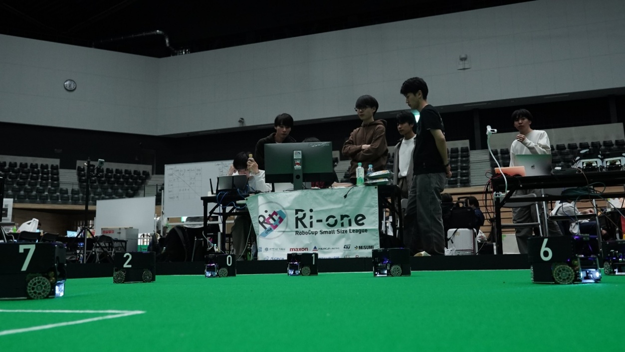 サッカーをプレイするロボット（上）と試合準備の様子