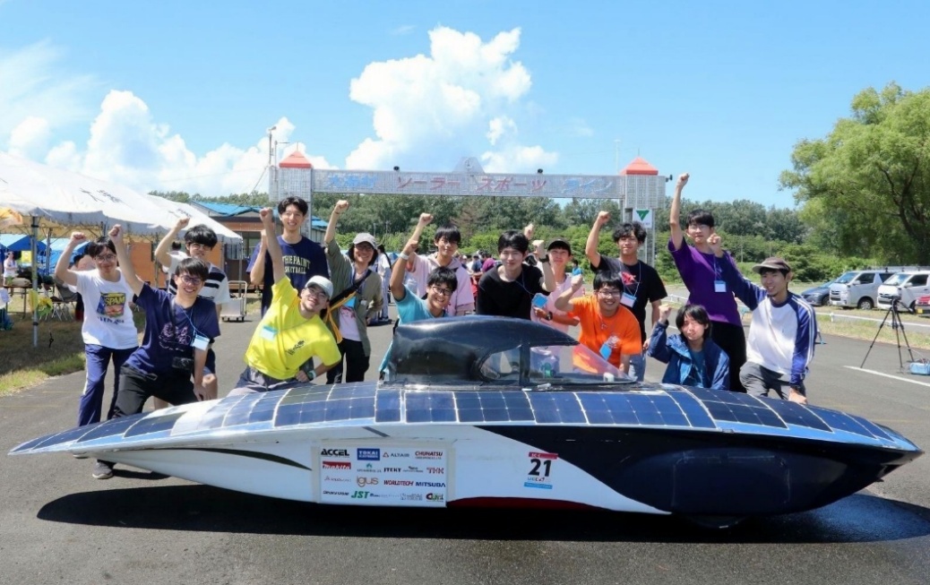 2025年の国内大会で総合優勝したソーラーカーを前に歓喜に沸く部員たち